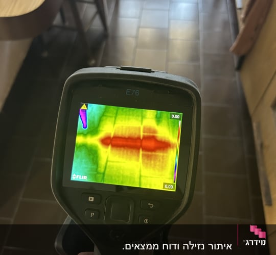 מד חום תרמי מציג תמונה צבעונית על רצפה